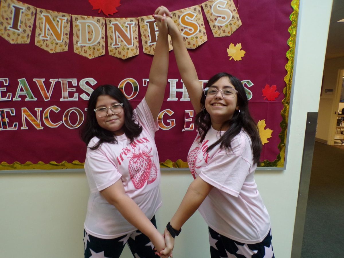 TWINNING GRINS! 
For Twin Day, 6th graders Evasol Fernandez and Dannia Rojas match outfits, making the shape of a diamond with their hands. Their matching colors and clothes show off their spirit. “Me and Dannia anyways mess up when trying to match, but when it's planned we remember more. We came up with that at the last minute. Dannia saw a pair of cute pajamas at 5 Below, We were FaceTiming at the moment. She thought it was super cute and super cozy and super comfy. It was also really soft and she said that we had to get them,” Evasol explained.